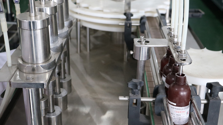 Машина для наполнения круглых бутылок на 500 мл с герметизирующим колпачком и звездообразным колесом